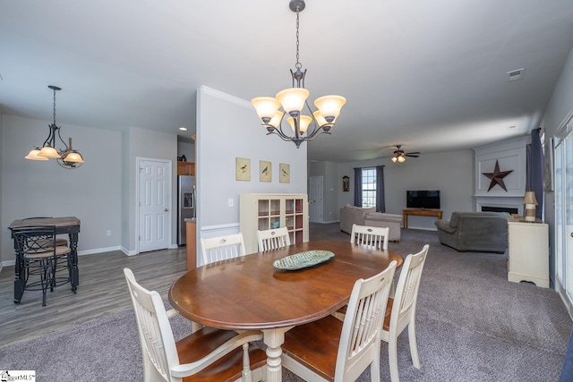 112 Pendock Ln, Piedmont, SC 29673 - carpeted dining area with a chandelier, a ceiling fan, and a fireplace