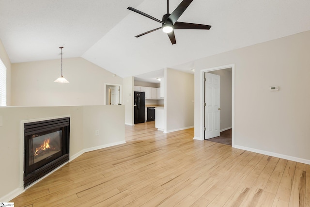 21 Lantern Ln, Greer, SC 29651 - unfurnished living room with ceiling fan, vaulted ceiling, a glass covered fireplace, and light wood-type flooring
