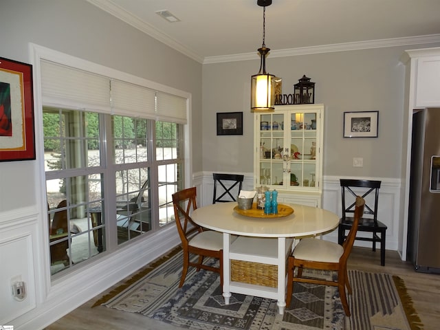 811 White Magnolia Dr, Inman, SC 29349 - dining space with ornamental molding, wood finished floors, a wainscoted wall, and a decorative wall