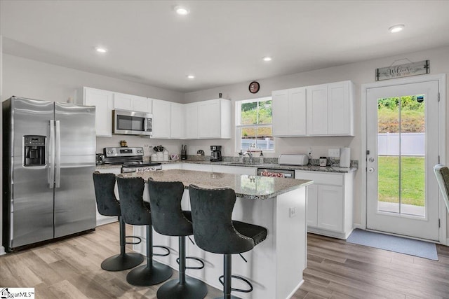 243 Lily Park Way, Easley, SC 29642 - kitchen with appliances with stainless steel finishes, a center island, white cabinets, a kitchen bar, and recessed lighting