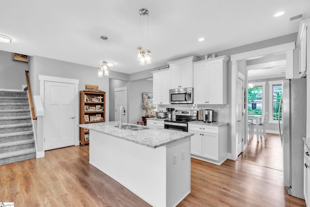 542 Drayton Hall Blvd, Duncan, SC 29334 - kitchen featuring appliances with stainless steel finishes, a center island with sink, light wood finished floors, white cabinets, and recessed lighting