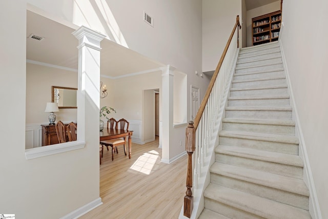 6 Castle Hall Ct, Simpsonville, SC 29681 - stairway with ornate columns, wood finished floors, ornamental molding, and a towering ceiling