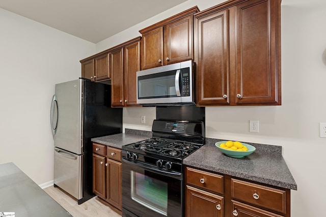 6 Castle Hall Ct, Simpsonville, SC 29681 - kitchen featuring appliances with stainless steel finishes, dark countertops, and light wood-style floors