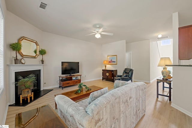 6 Castle Hall Ct, Simpsonville, SC 29681 - living area featuring a ceiling fan, light wood-type flooring, and a fireplace with raised hearth