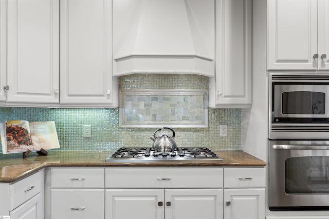 623 N Main St Unit Iii, Unit Iii, Greenville, SC 29601 - kitchen featuring appliances with stainless steel finishes, custom range hood, white cabinets, and backsplash