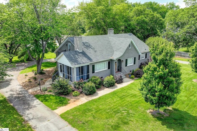 2109 Hudson Rd, Greer, SC 29650 - view of front of home with roof with shingles, a chimney, a front yard, and a sunroom