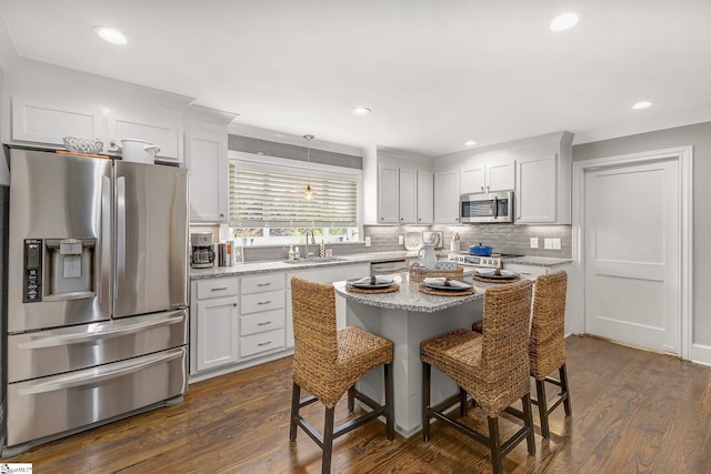 2109 Hudson Rd, Greer, SC 29650 - kitchen featuring appliances with stainless steel finishes, dark wood-style flooring, a breakfast bar, decorative backsplash, and recessed lighting