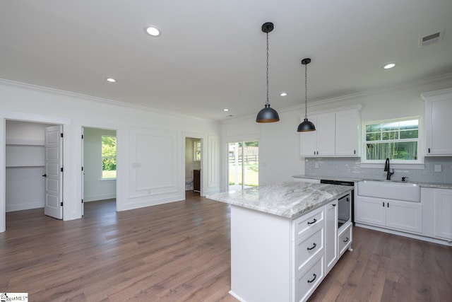 103 Cedar Falls Rd, Fountain Inn, SC 29644 - kitchen with crown molding, healthy amount of natural light, decorative backsplash, white cabinetry, and a kitchen island