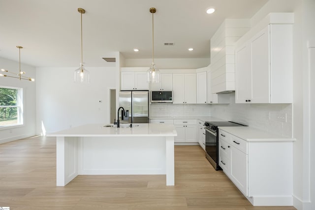 200 Folk Rd, Chesnee, SC 29323 - kitchen with stainless steel appliances, light wood finished floors, decorative backsplash, a center island with sink, and recessed lighting