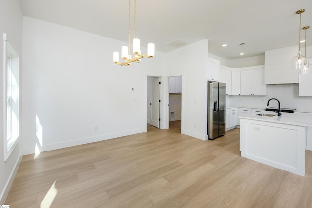 196 Folk Rd, Chesnee, SC 29323 - kitchen with stainless steel fridge, light wood finished floors, light countertops, a chandelier, and white cabinetry