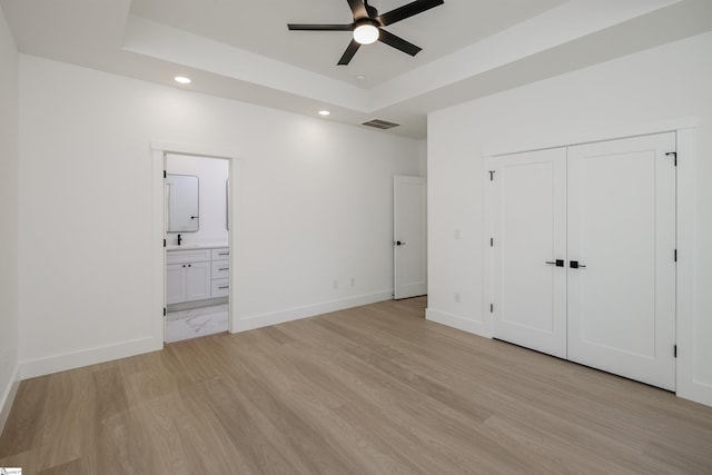 196 Folk Rd, Chesnee, SC 29323 - unfurnished bedroom featuring recessed lighting, light wood-style flooring, a tray ceiling, connected bathroom, and a closet
