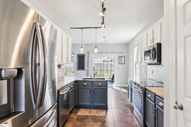 236 Worcester Ln, Easley, SC 29642 - kitchen featuring appliances with stainless steel finishes, a peninsula, backsplash, white cabinetry, and decorative light fixtures