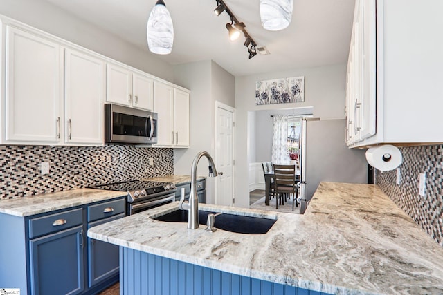 236 Worcester Ln, Easley, SC 29642 - kitchen featuring appliances with stainless steel finishes, blue cabinets, white cabinets, and light stone countertops