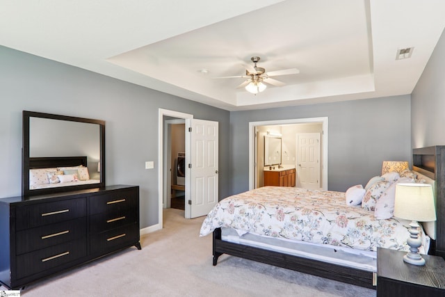 236 Worcester Ln, Easley, SC 29642 - bedroom featuring a raised ceiling, light colored carpet, washer / clothes dryer, ensuite bathroom, and ceiling fan