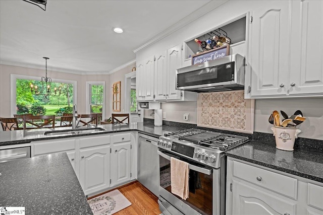 104 Shadowcreek Ct, Simpsonville, SC 29681 - kitchen featuring stainless steel appliances, crown molding, white cabinetry, dark stone counters, and pendant lighting