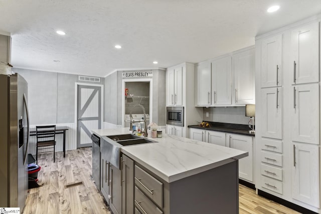 419-425 Chesapeake Trl, Pickens, SC 29671 - kitchen with stainless steel appliances, white cabinetry, light wood-style floors, a center island with sink, and gray cabinets
