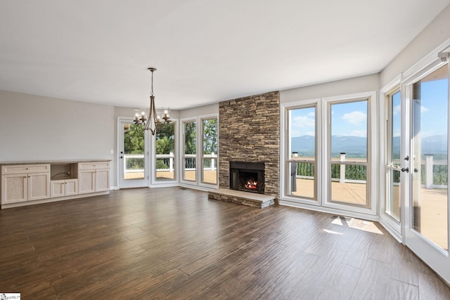 600 Packs Mountain Ridge Rd, Taylors, SC 29687 - unfurnished living room with dark wood-style floors, a chandelier, and a stone fireplace