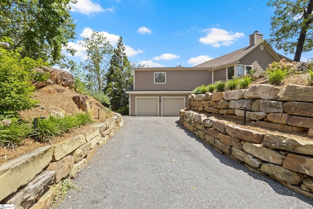 600 Packs Mountain Ridge Rd, Taylors, SC 29687 - view of side of home with a garage, asphalt driveway, and a chimney