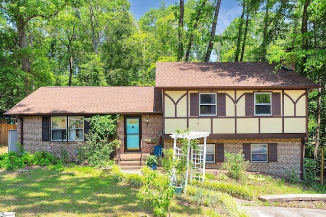5 Nova St, Taylors, SC 29687 - tudor-style house featuring brick siding, a front yard, a shingled roof, and stucco siding