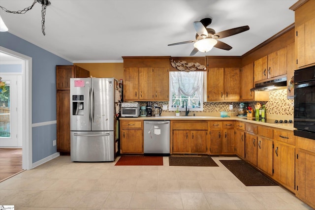 5 Nova St, Taylors, SC 29687 - kitchen with black appliances, under cabinet range hood, brown cabinetry, light countertops, and ceiling fan