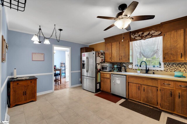 5 Nova St, Taylors, SC 29687 - kitchen featuring stainless steel appliances, decorative backsplash, brown cabinetry, a ceiling fan, and light countertops