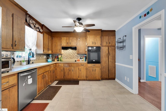 5 Nova St, Taylors, SC 29687 - kitchen featuring black appliances, under cabinet range hood, tasteful backsplash, light countertops, and brown cabinetry