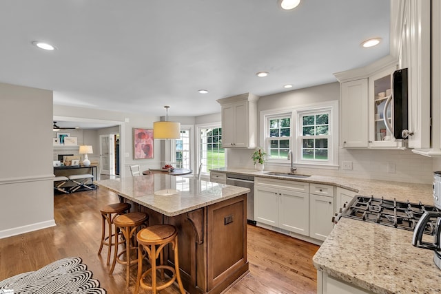 111 Brandon Way, Simpsonville, SC 29681 - kitchen with appliances with stainless steel finishes, light wood-type flooring, light stone counters, backsplash, and a center island