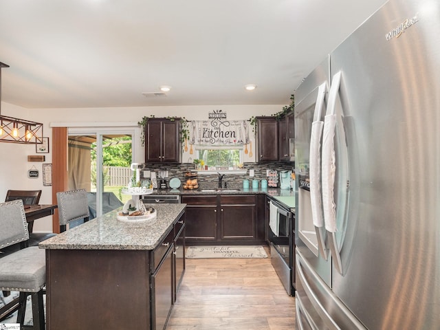 126 Blue Springs Way, Simpsonville, SC 29680 - kitchen with appliances with stainless steel finishes, dark brown cabinets, light wood-style flooring, a kitchen island, and recessed lighting
