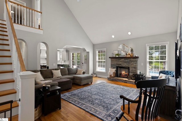 6 Mandarin Cir, Taylors, SC 29687 - living area featuring arched walkways, a fireplace, light wood-type flooring, stairs, and high vaulted ceiling