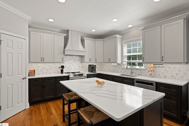 6 Mandarin Cir, Taylors, SC 29687 - kitchen with wall chimney range hood, ornamental molding, appliances with stainless steel finishes, a breakfast bar, and a kitchen island