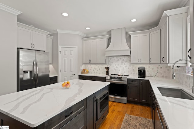 6 Mandarin Cir, Taylors, SC 29687 - kitchen with stainless steel appliances, premium range hood, crown molding, tasteful backsplash, and light wood-type flooring