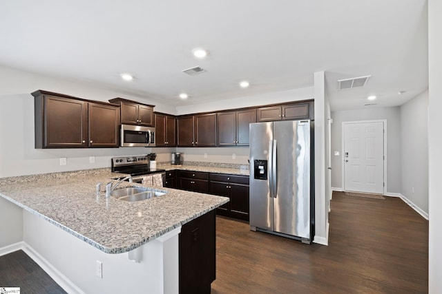 259 Millen Dr, Woodruff, SC 29388 - kitchen with stainless steel appliances, dark brown cabinetry, a peninsula, dark wood-style flooring, and recessed lighting