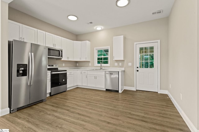 1231 Apalache St, Greer, SC 29651 - kitchen featuring stainless steel appliances, wood finished floors, light countertops, and white cabinets