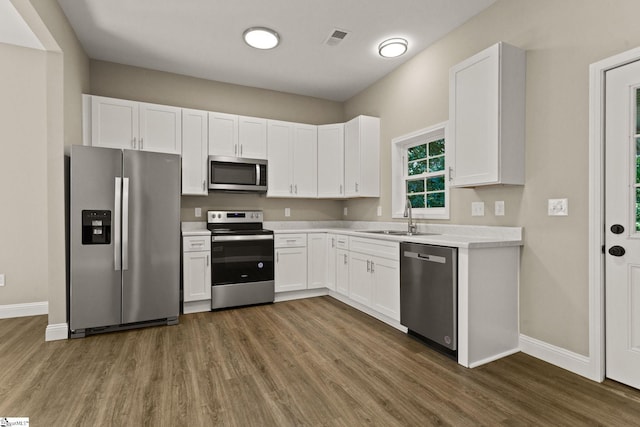 1231 Apalache St, Greer, SC 29651 - kitchen with stainless steel appliances, wood finished floors, light countertops, and white cabinets