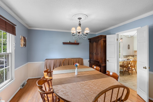 217 Devenger Rd, Greer, SC 29650 - dining area featuring a chandelier, light wood-style flooring, a textured ceiling, and crown molding