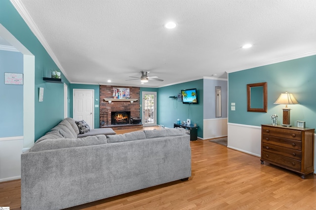 217 Devenger Rd, Greer, SC 29650 - living area with a ceiling fan, a textured ceiling, a brick fireplace, ornamental molding, and light wood finished floors