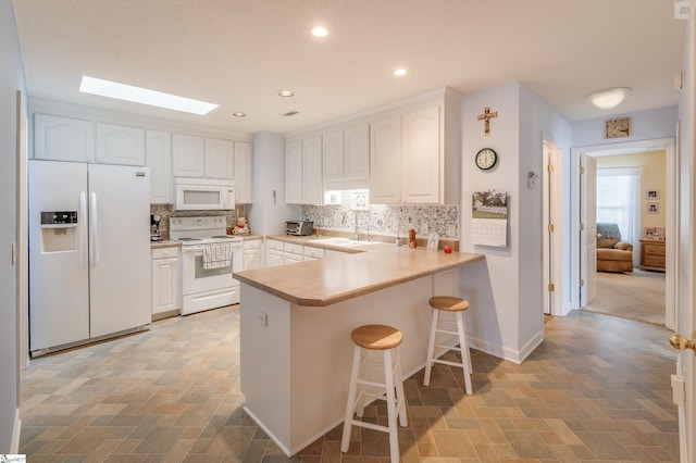 110 Baldwin Pl, Easley, SC 29642 - kitchen featuring white appliances, a peninsula, white cabinets, backsplash, and a skylight