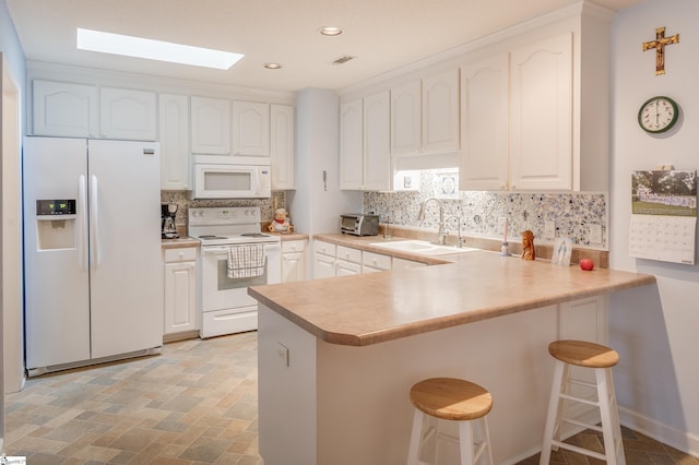 110 Baldwin Pl, Easley, SC 29642 - kitchen with white appliances, a skylight, a peninsula, white cabinetry, and recessed lighting