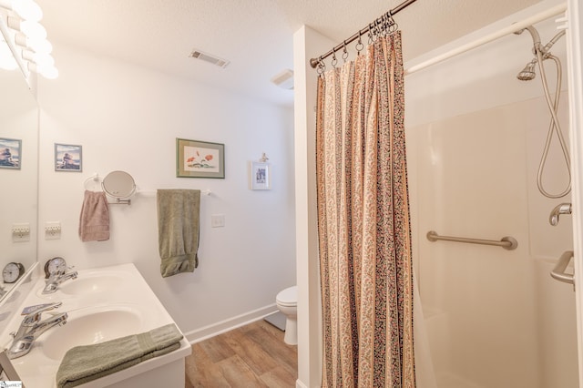 110 Baldwin Pl, Easley, SC 29642 - full bathroom featuring wood finished floors, double vanity, curtained shower, and a textured ceiling