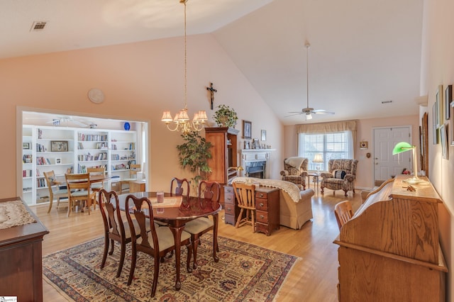 110 Baldwin Pl, Easley, SC 29642 - dining space featuring high vaulted ceiling, a fireplace, a ceiling fan, light wood-style flooring, and a chandelier