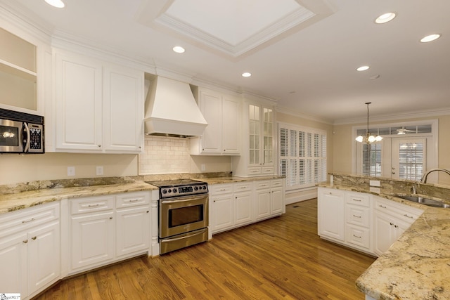 3 Henson Pl, Greer, SC 29650 - kitchen with appliances with stainless steel finishes, custom exhaust hood, crown molding, wood finished floors, and white cabinetry
