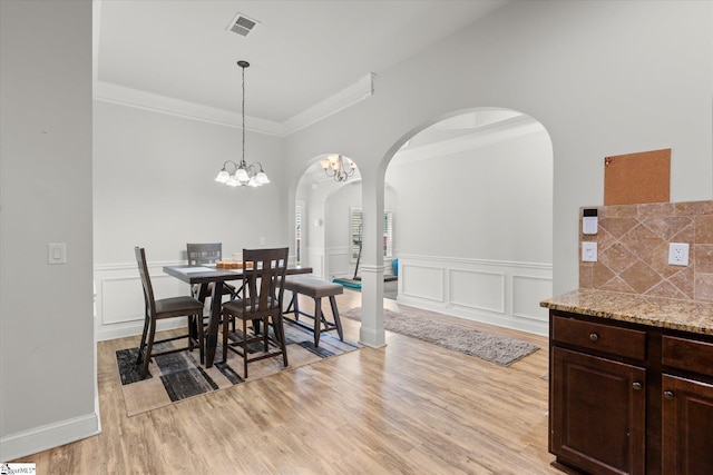 505 E Czardas Way, Woodruff, SC 29375 - dining room with crown molding, arched walkways, light wood-style floors, a wainscoted wall, and a decorative wall