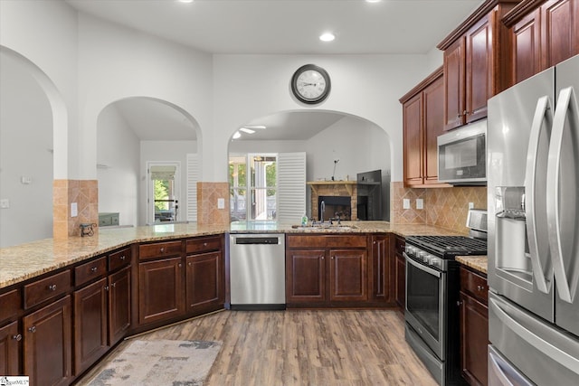 505 E Czardas Way, Woodruff, SC 29375 - kitchen featuring appliances with stainless steel finishes, light wood-style floors, recessed lighting, decorative backsplash, and light stone counters