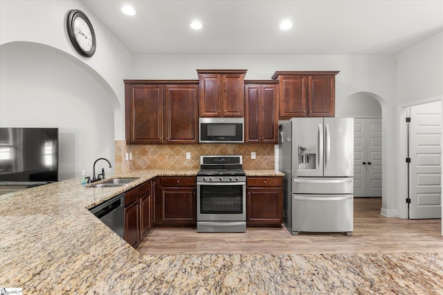 505 E Czardas Way, Woodruff, SC 29375 - kitchen featuring stainless steel appliances, arched walkways, light stone countertops, decorative backsplash, and dark brown cabinetry