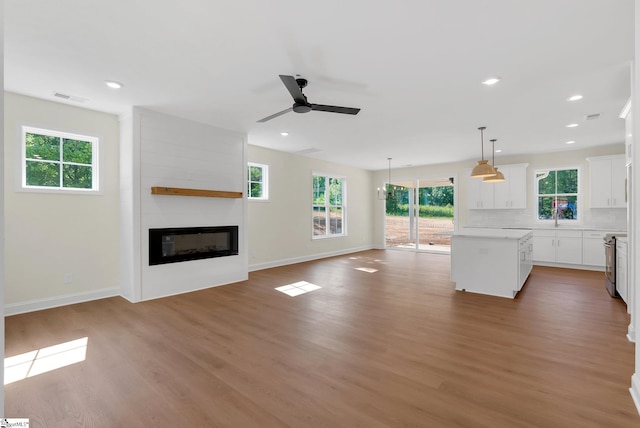 293 Pine Hills Rd, Woodruff, SC 29388 - unfurnished living room featuring wood finished floors, ceiling fan, a large fireplace, and recessed lighting