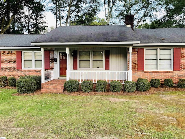 504 N Adair St, Clinton, SC 29325 - view of front facade with a chimney, a porch, brick siding, and a front yard