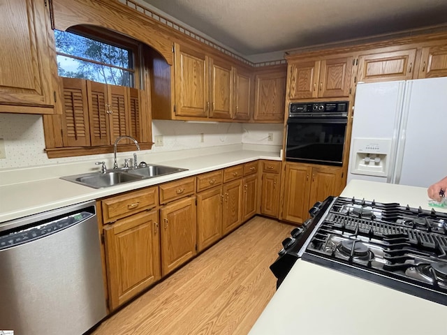 504 N Adair St, Clinton, SC 29325 - kitchen with appliances with stainless steel finishes, light wood-type flooring, light countertops, and brown cabinetry