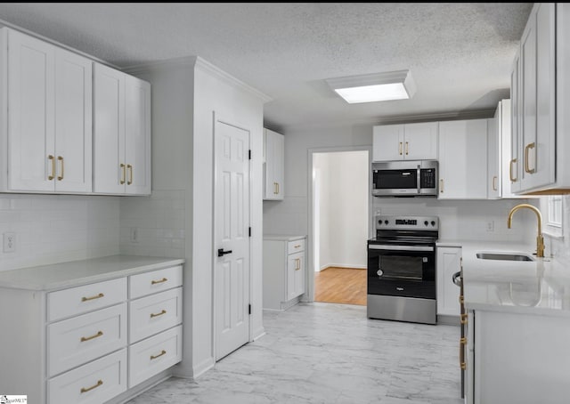 612 Walnut Way, Anderson, SC 29626 - kitchen with appliances with stainless steel finishes, light marble finish flooring, decorative backsplash, white cabinetry, and a textured ceiling
