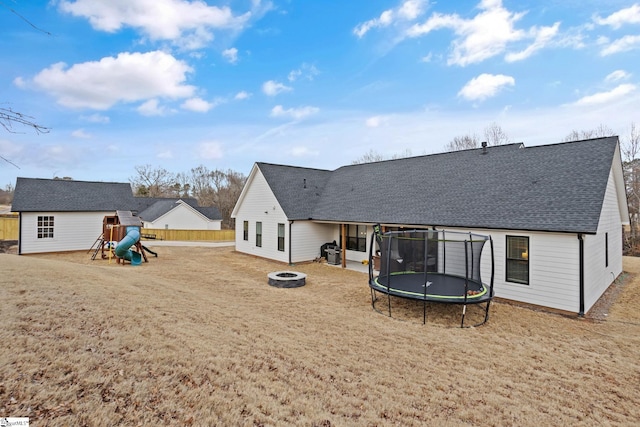 12 Beech Creek Ct, Greer, SC 29651 - back of house featuring an outdoor fire pit, a trampoline, a playground, roof with shingles, and a lawn