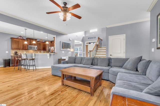 911 Devenger Rd, Greer, SC 29650 - living room featuring ceiling fan, crown molding, stairway, and light wood-type flooring